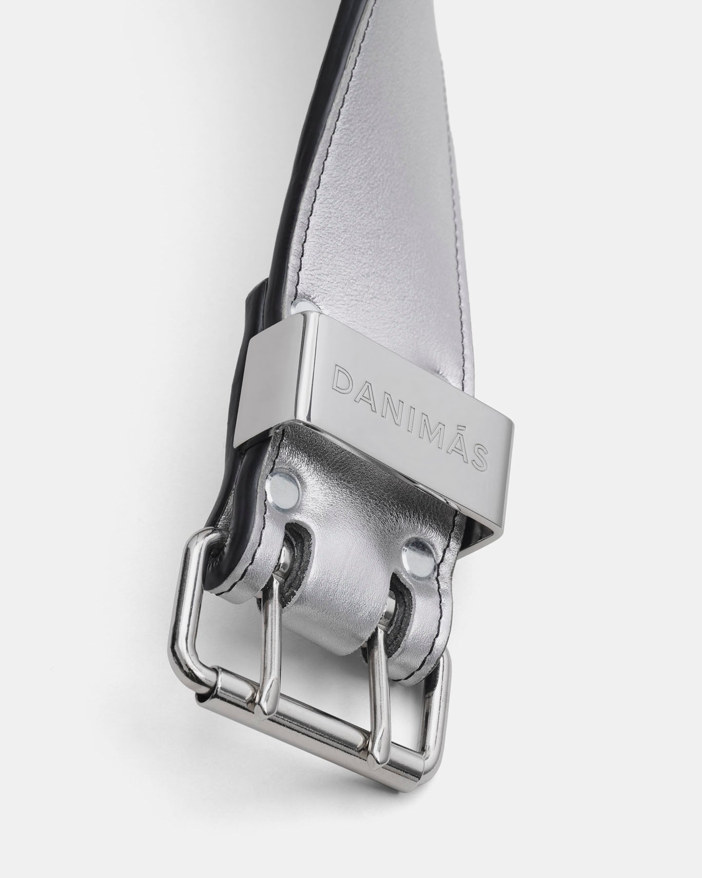 Close-up of a belt with a silver buckle on a white background