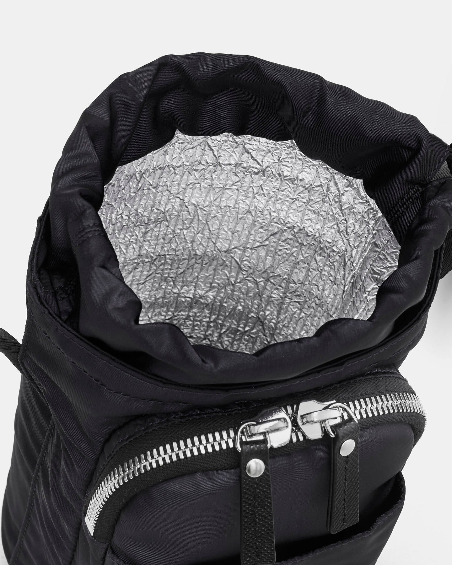 Black crossbody water bottle bag with a silver patterned interior lining on a white background